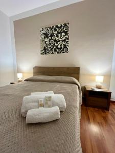 Casa SantaにあるLa Rosa sul Mareのベッドとタオル2枚のある寝室
