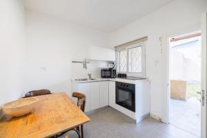a kitchen with a wooden table and a wooden table and a table and a kitchen at Herbert Apartments in Beer Sheva +6 photos