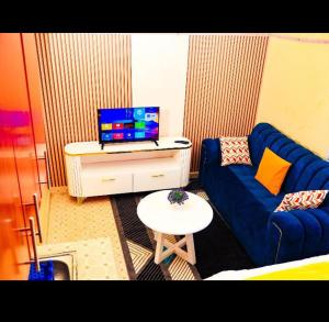a living room with a blue couch and a table at Cozy Homes in Thika +1 photo