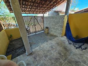 eine Außenterrasse mit einer Hängematte auf einer Veranda in der Unterkunft Sol & Vento Chalés - Chalé Cardeiro in São Miguel do Gostoso + 5 Fotos