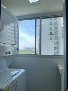 卡塔赫纳Apartment with direct access to the Sea in CTG的厨房设有大窗户和微波炉。