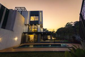 a house with a pool in front of it at Aviran Villa 5BHK - Jacuzzi House in Lonavala