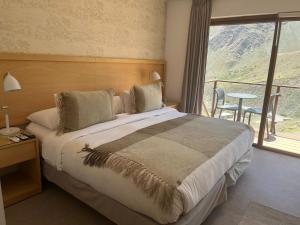Refugio Lo ValdésにあるLodge El Moradoのベッドルーム(大型ベッド1台、バルコニー付)