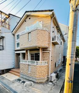 a brick building with a balcony on a street at New open! Dream ASUNARO 5 minuites from Shinsaibashi in Osaka