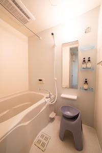 a bathroom with a tub and a stool in it at New open! Dream ASUNARO 5 minuites from Shinsaibashi in Osaka +39 photos
