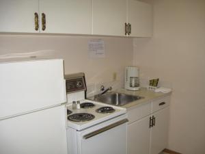 a kitchen with a stove and a sink and a refrigerator at Pals Motel and RV Park in Medicine Hat