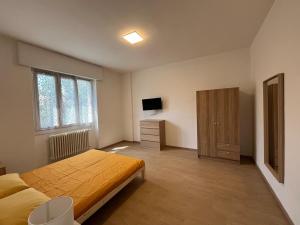 a bedroom with a bed and a dresser and a television at Villetta TOP al Vallone in Pavia