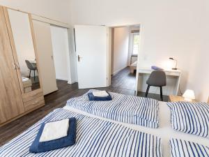 a bedroom with two beds and a desk and a chair at Ferienwohnung Alte Sensenschärferfabrik in Franken Vorstadt