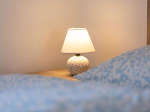 a lamp sitting on a table next to a bed at Ferienwohnung Alte Sensenschärferfabrik in Franken Vorstadt