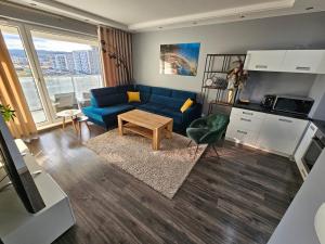 a living room with a blue couch and a table at Przytulny apartament do wynajęcia in Reda