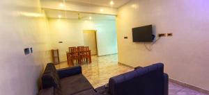 a living room with a couch and a tv and a table at Shivalaya's 2BHK Service Apartment Near Adiyogi & Siruvani in Alāndurai +25 photos