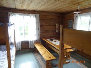 um quarto com uma mesa e um banco numa cabina de madeira em Vuohensaari Camping Ahtela's cottage em Salo