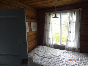 a bedroom with a bed and a large window at Vuohensaari Camping Ahtela's cottage in Salo