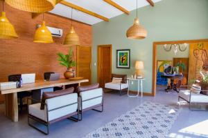 a living room with a table and chairs and pendant lights at Pousada Ponta de Areia in Prado