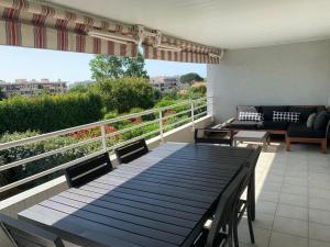a deck with a table and chairs on a balcony at Charmant 3 pièces vue mer in Antibes