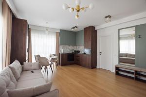 a living room with a white couch and a kitchen at Moldovei 2 Apartments by Central Park in Cluj-Napoca