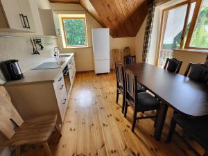 a kitchen and dining room with a table and chairs at Sodyba - Antalieptės marios in Zarasai