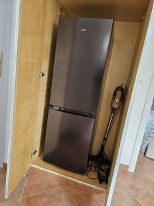 a stainless steel refrigerator in a corner of a room at Stella Marina Apartment in Fregene