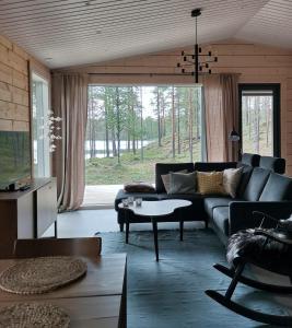 a living room with a couch and a large window at Saga Tarula in Kuusamo