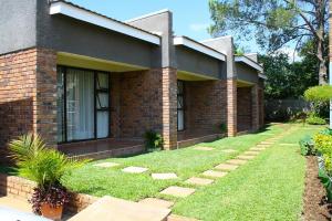 a brick house with a lawn in front of it at Mpala Boutique Hotel in Bulawayo