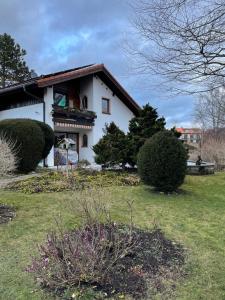 a white house with a garden in front of it at Alpen-Stadt Idylle in Dietramszell