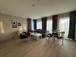 a living room with a couch and a table and chairs at Tindgaard apartment in Ørsvåg