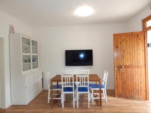 Un comedor con mesa y sillas y un televisor. en MareBlu Apartment with patio, en Marina di Castagneto Carducci