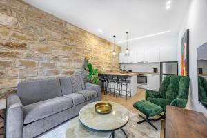 a living room with a couch and a stone wall at Olga Premium Apartments in Limassol