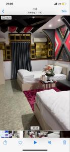 Un dormitorio con dos camas y una mesa con flores. en Minh Khang Hotel, en Duyên Trữ