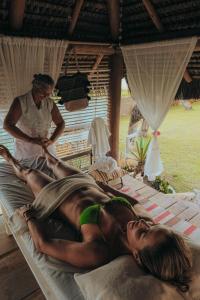 a man in a green bikini laying on a bed with a woman at Pousada Ponta de Areia in Prado
