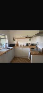 a kitchen with white cabinets and a sink at Chestnut Cottage in Great Ellingham