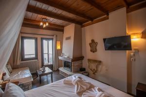 a bedroom with a bed and a fireplace and a tv at Archontiko Zakoni in Neochori