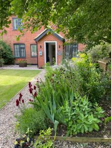 a garden with flowers in front of a building at Chestnut Cottage in Great Ellingham