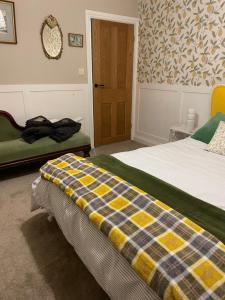 a bedroom with a bed with a checkered blanket at Chestnut Cottage in Great Ellingham