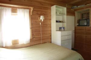 een slaapkamer met een bed, een raam en een televisie bij Tähdikki Cottage in Kalmari