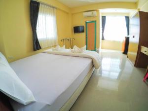 two beds in a room with yellow walls at Wansiri Mansion in Songkhla