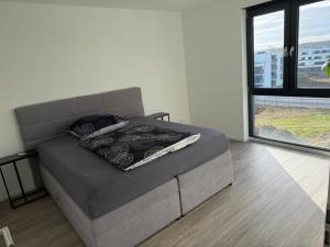 a bed in a room with a large window at Penthousewohnung zum Wohlfühlen in Weyhausen