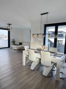 a dining room with a white table and chairs at Penthousewohnung zum Wohlfühlen in Weyhausen +11 photos