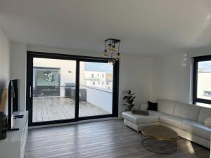 a living room with a couch and a large window at Penthousewohnung zum Wohlfühlen in Weyhausen