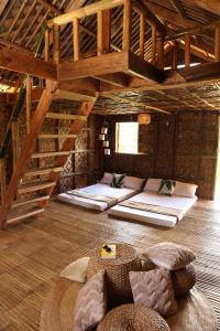 a room with several beds in a room with wooden ceilings at Camp Irog Daraitan in Damasanan