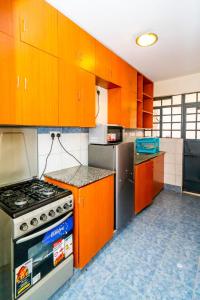 a kitchen with orange cabinets and a stove at Adriel Stay in Nairobi
