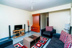 a living room with a couch and a tv at Adriel Stay in Nairobi