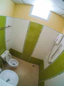 La salle de bains est pourvue de toilettes, d'un lavabo et d'une fenêtre. dans l'établissement Wansiri Mansion, à Songkhla