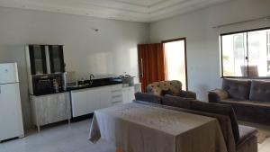 a kitchen with a couch and a table in a room at Casa Amarte - Sobrado Privado com Garagem in Guaíra