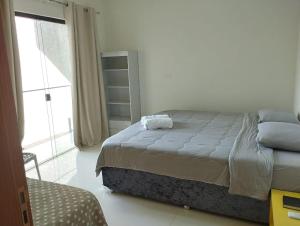 a bedroom with a bed and a large window at Casa Amarte - Sobrado Privado com Garagem in Guaíra