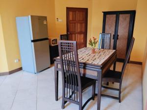 a kitchen with a table and chairs and a refrigerator at Maijom Apartments in Jomtien Beach +14 photos