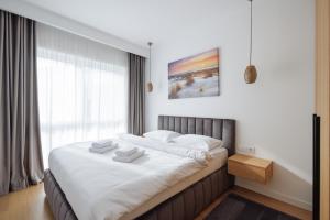 a bedroom with a large bed with white sheets at Moldovei 2 Apartments by Central Park in Cluj-Napoca