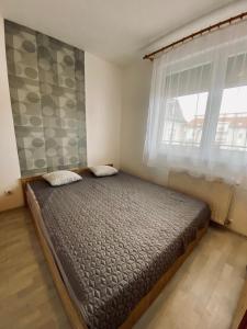 a bedroom with a large bed with a window at Byblos Wellness Apartman Siófok in Siófok +16 photos