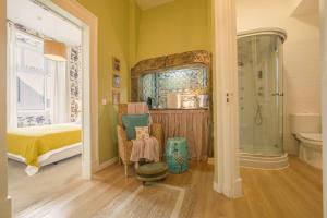 a bathroom with a shower and a bed in a room at Sapateiros 44 in Lisbon
