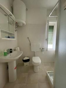 a white bathroom with a toilet and a sink at Vecchia Riva in Riva del Garda